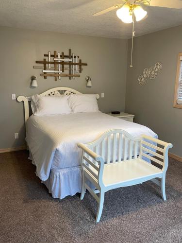 a bedroom with a white bed with a bench at Crown Lake Resort in Horseshoe Bend
