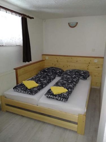 Un dormitorio con una cama con almohadas amarillas. en Apartmán Pavla, en Ostružná
