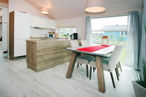 a kitchen with a table and chairs in a kitchen at Ferienhaus Seeadler mit Sauna am Dümmer See in Dümmer