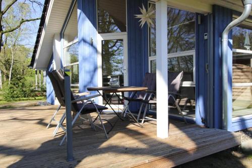 a porch with a table and chairs on a house at Ferienhaus Seeadler mit Sauna am Dümmer See in Dümmer