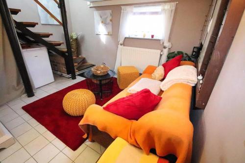 uma sala de estar com um sofá amarelo e almofadas vermelhas em Holiday Home Storkow - DBS05105-F em Storkow