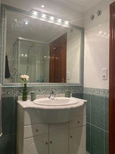 a bathroom with a sink and a large mirror at PISO VOLVORETA in O Grove