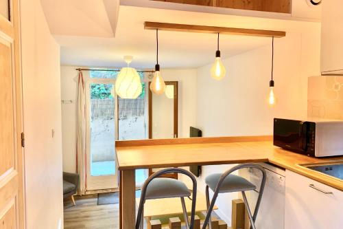 une cuisine avec une table et deux tabourets dans l'établissement #AY L'astucieux Fully-equipped flat, à La Tronche