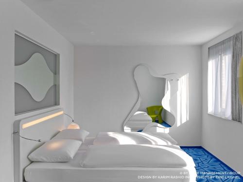 a white room with two beds and a window at Prize by Radisson, Hamburg City in Hamburg