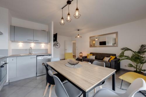 une cuisine et un salon avec une table et des chaises dans l'établissement L'Art de Ville - 2 bedroom near the city center terrace and garage, à Annecy