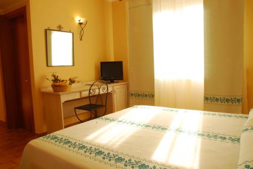 A bed or beds in a room at LE NEREIDI Hotel & Residence con Piscina-Tennis-Fitness-Parcheggio coperto-Sala Conferenze