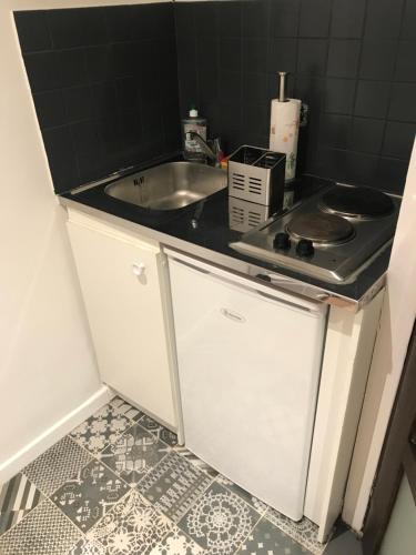 une petite cuisine avec un évier et une cuisinière dans l'établissement Superbe appartement Paris/Bercy (12e) wifi&Netflix, à Paris