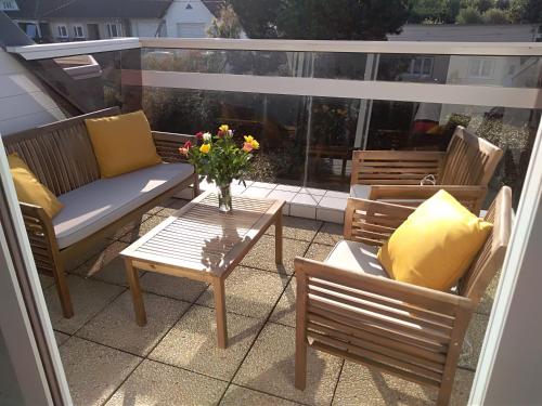 eine Terrasse mit Stühlen und einem Tisch mit einer Blumenvase in der Unterkunft Appartement ds résidence privée avec parking privé in Berck-sur-Mer
