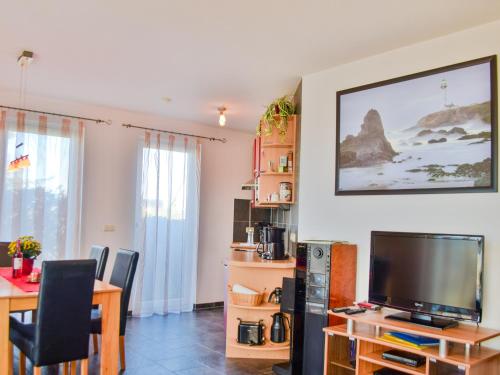 a living room with a tv and a table with chairs at Ferienhaus Bodden in Neuendorf