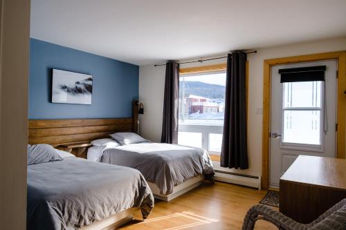 1 dormitorio con 2 camas y ventana en Auberge de Jeunesse Le Camp De Base, en L'Anse-Saint-Jean