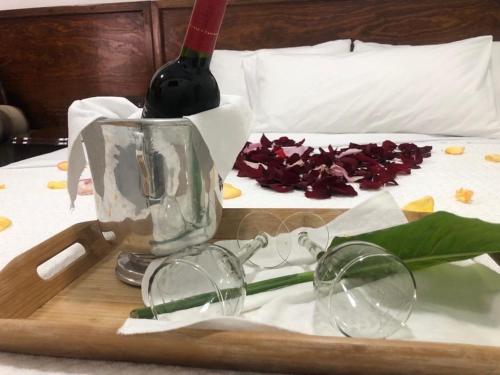 a tray with glasses and a bottle of wine on a bed at Hotel CALLI YOLOTL Teotihuacan in San Juan Teotihuacán