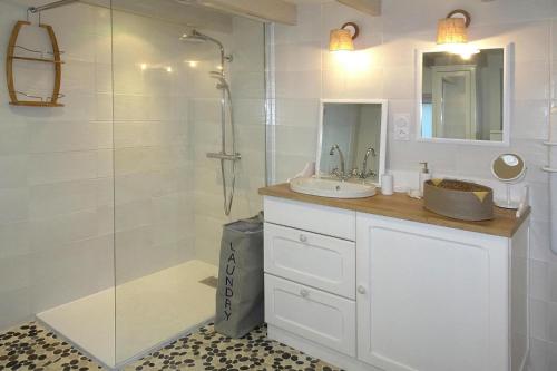 ein weißes Bad mit einem Waschbecken und einer Dusche in der Unterkunft Holiday Home Plougasnou - BRE05101b-F in Plougasnou