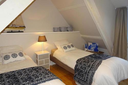 Zimmer im Dachgeschoss mit 2 Betten und einer Lampe in der Unterkunft Holiday Home Plougasnou - BRE05101b-F in Plougasnou