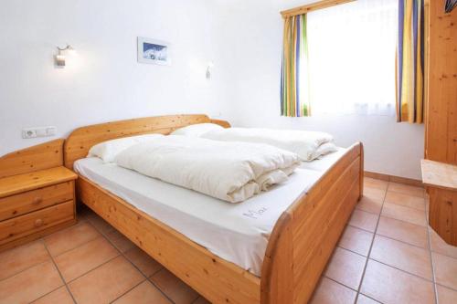 a bed with a wooden frame in a room at Chalet, Hochkrimml in Krimml