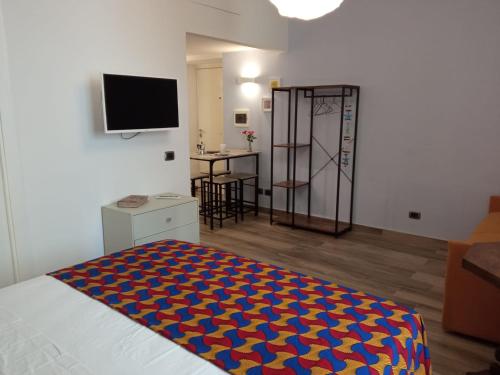 ein Schlafzimmer mit einem Bett mit einer blauen und roten Decke in der Unterkunft Cappuccini Express House in Pozzuoli