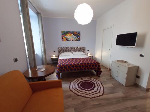 ein Schlafzimmer mit einem Bett, einem Sofa und einem TV in der Unterkunft Cappuccini Express House in Pozzuoli