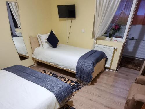 a hotel room with two beds and a television at Roca House in Braşov