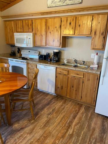 a kitchen with wooden cabinets and a wooden table and a table and a tablektop at Crown Lake Resort in Horseshoe Bend