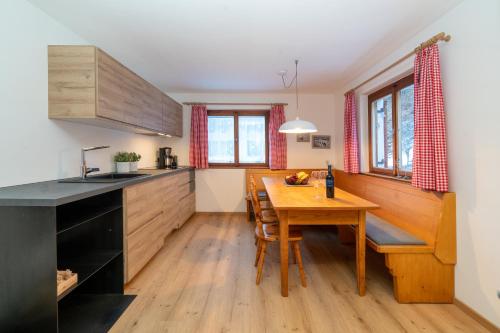 uma cozinha com uma mesa de madeira e um piso de madeira em Haus Buachwald em Schruns