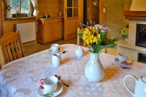a table with a white vase with flowers on it at Holiday home by the lake, private garden, Oswino in Oswino