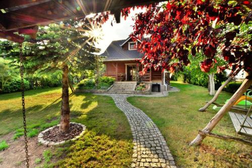 a house with a tree in the yard at Holiday home by the lake, private garden, Oswino in Oswino