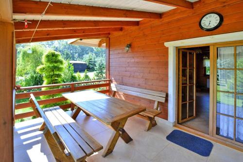 a wooden table and bench on the porch of a house at Holiday home by the lake, private garden, Oswino in Oswino
