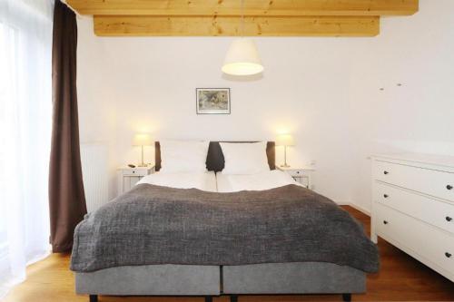 a bedroom with a large bed with two lamps at Apartment in Lissendorf with a paid private sauna in Lissendorf