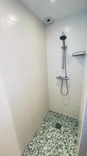 La salle de bains est pourvue d'une douche et de carrelage. dans l'établissement Superbe appartement Vue Mer et Piscine, à Bandol