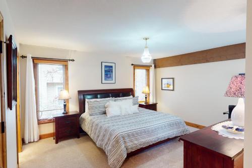 a bedroom with a large bed and two windows at Avon Golf Getaway in Avon