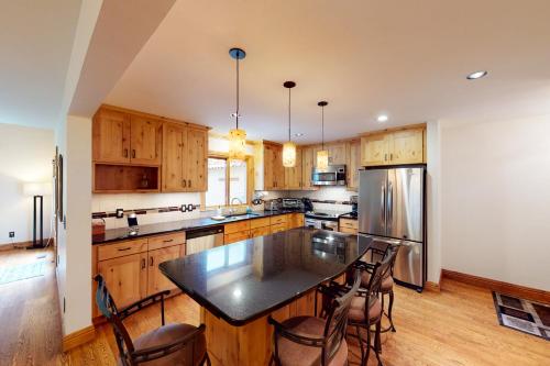 a kitchen with wooden cabinets and a black counter top at Avon Golf Getaway in Avon