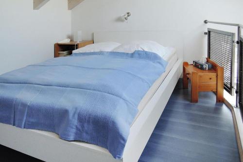 a bedroom with a large bed with a blue blanket at Apartment, Zell im Wiesental in Zell im Wiesental