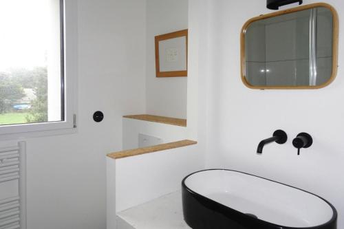 a bathroom with a black toilet and a mirror at Holiday Home, La Trinite-sur-Mer in La Trinité-sur-Mer