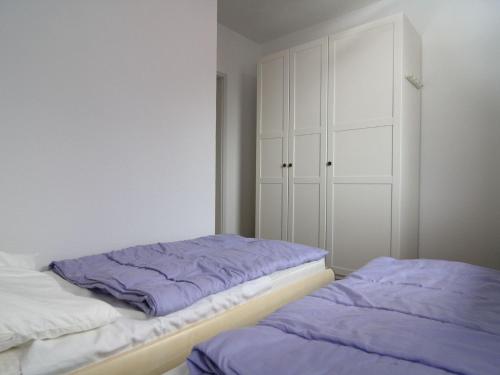 - une chambre avec 2 lits et des draps violets dans l'établissement Apartment, St Peter-Ording, à Sankt Peter-Ording