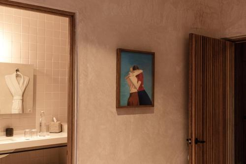 a bathroom with a painting of a woman on the wall at Casa Antonieta in Oaxaca City