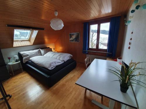Un dormitorio con una cama y una mesa. en Schöne 3 1/2 Zimmer Wohnung in der Zentralschweiz, 