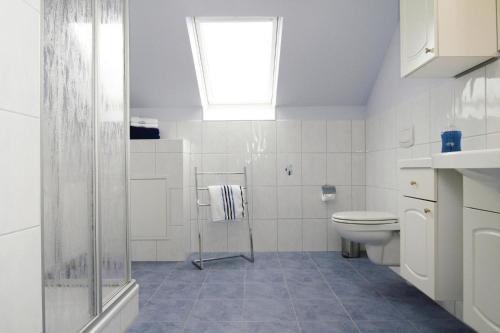 a white bathroom with a toilet and a window at Apartment, Burow in Gischow