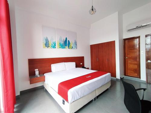 a bedroom with a large bed with a red blanket at HOTEL SAN JUAN, Tarapoto in Tarapoto