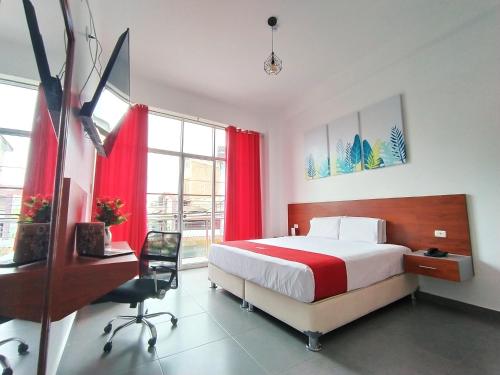 1 dormitorio con 1 cama con cortinas rojas y escritorio en HOTEL SAN JUAN, Tarapoto, en Tarapoto