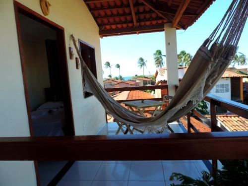a hammock on a balcony with a view of the ocean at Suíte das flores em Guajiru in Trairi