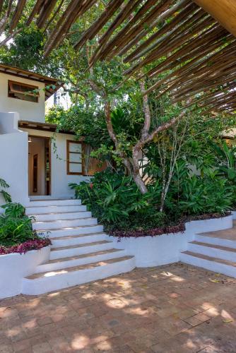 a set of stairs leading up to a house with a tree at DA GRAÇA HOTEL in Trancoso