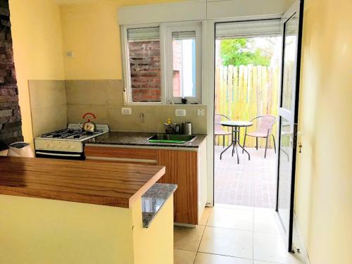 a kitchen with a stove and a counter with a table at Cabañas Sendero de Pinos - Alquileres RV in Monte Hermoso