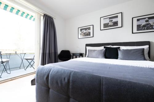 a bedroom with a large bed and a balcony at Armotti Weissenbühl 1 Bedroom Apartment in Bern