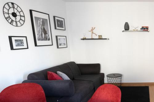 a living room with a couch and a clock on the wall at Armotti Weissenbühl 1 Bedroom Apartment in Bern