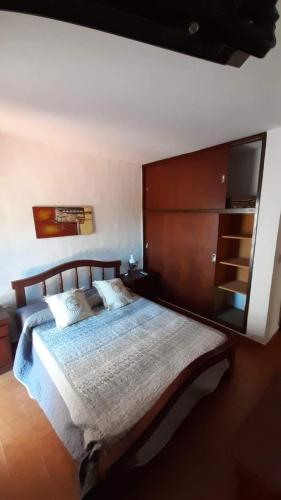 a bedroom with a large bed with a wooden headboard at Departamentos Carlos Paz bajada al lago in Villa Carlos Paz