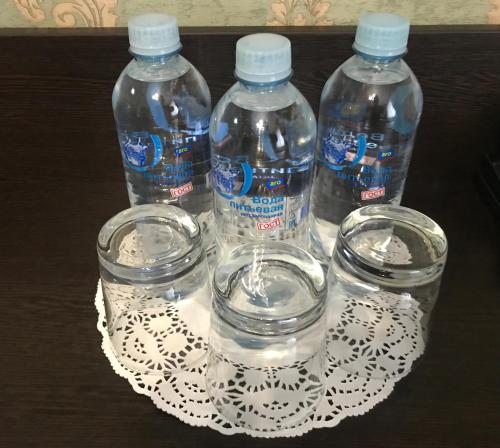 three bottles of water on a plate on a table at Hotel Malvida in Vidnoye