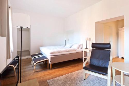 een slaapkamer met een bed, een stoel en een tafel bij Apartments in the Sudhaus, Schwerin in Schwerin