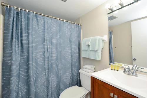 a bathroom with a shower curtain and a toilet at Canal 313 - Right in Siesta Key Village! in Siesta Key