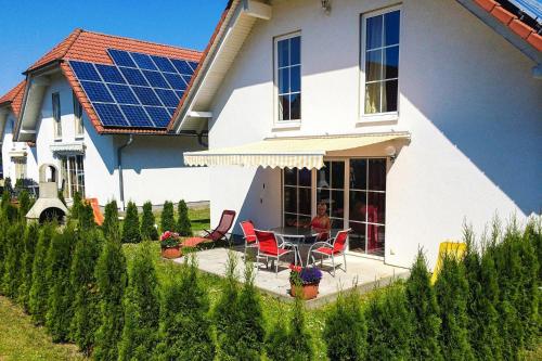 a house with a solar roof with a table and chairs at Cottages at the Kummerower See Verchen in Verchen