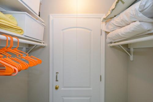 a closet with orange organizers and a white door at Canal 313 - Right in Siesta Key Village! in Siesta Key
