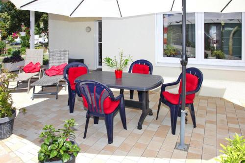 a table and chairs with an umbrella on a patio at Ferienhaus Adler in Mirow in Mirow